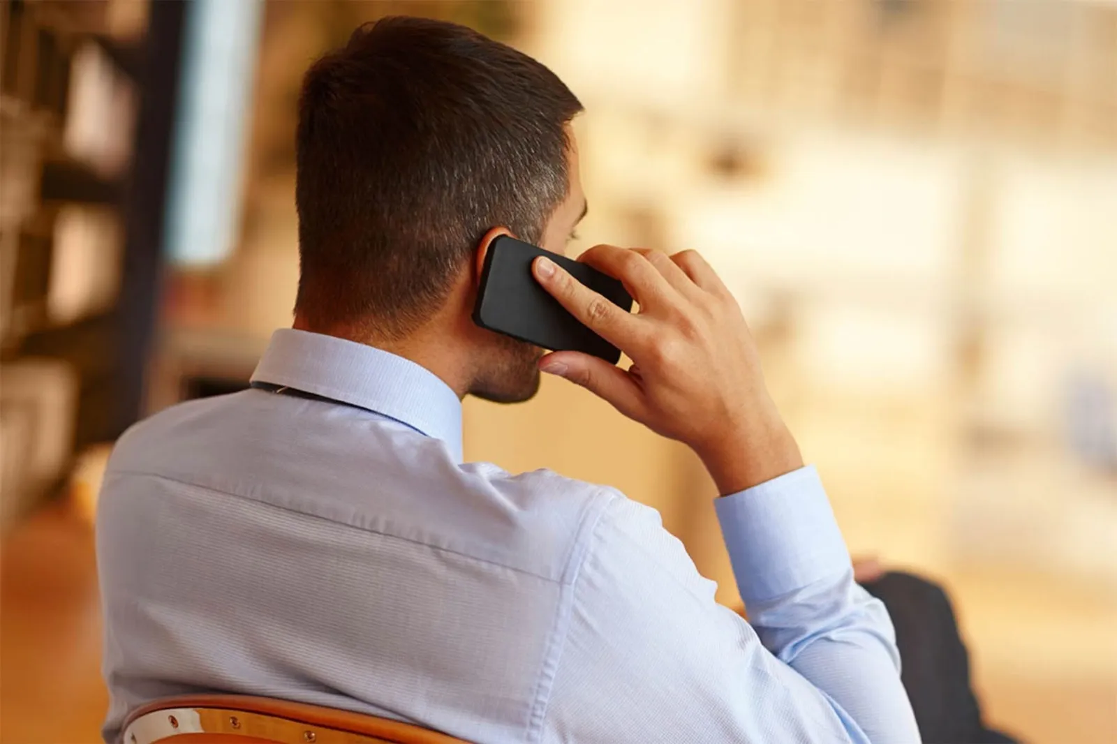 Professional taking a paid phone call at his desk